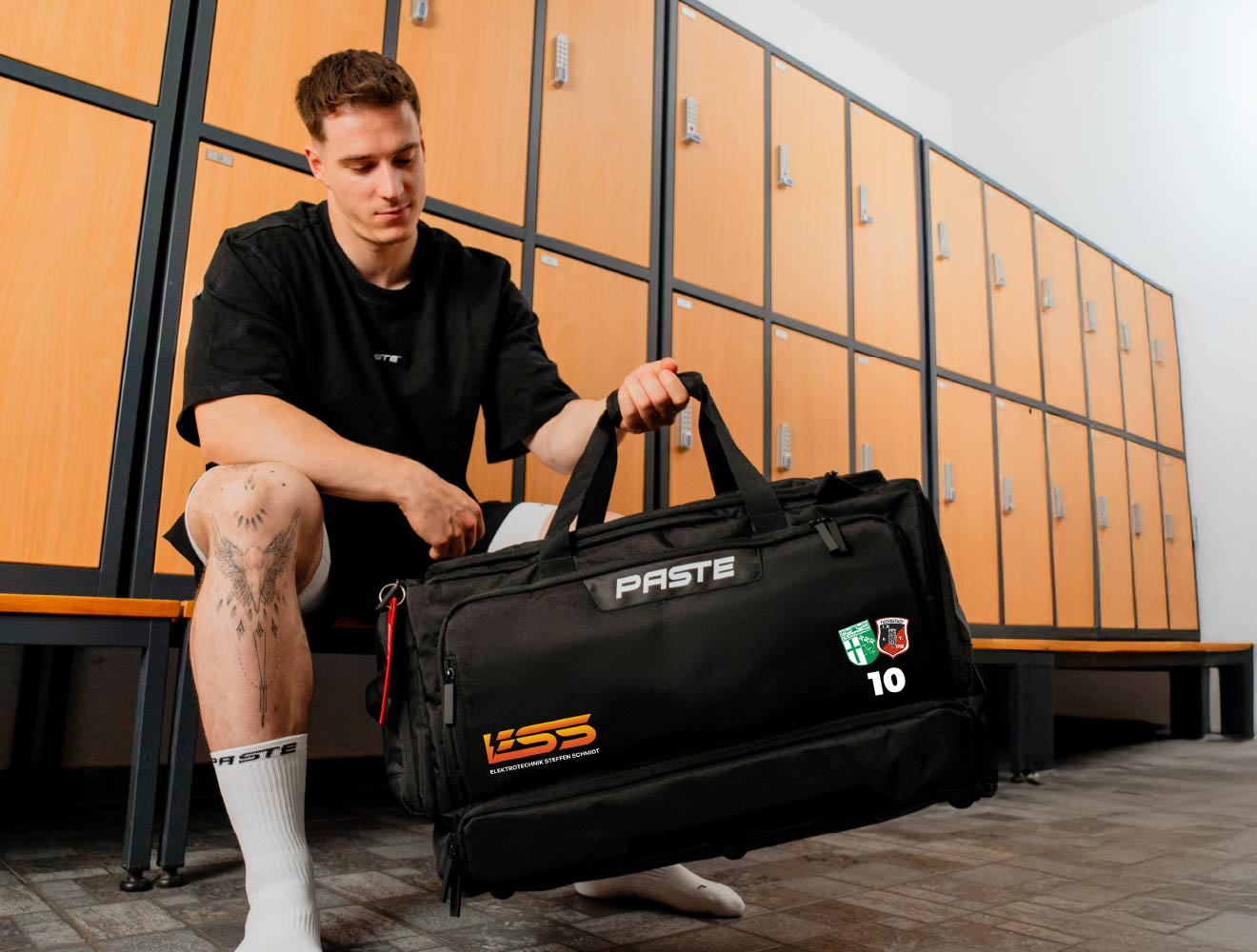 Personalisierte PASTE Sporttasche mit Vereinslogo und Rückennummer in der Umkleide.